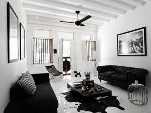 Чтобы черно-белая гостиная смотрелась красиво, рекомендуется покупать мебель черного оттенка, а стены окрашивать в белый цвет