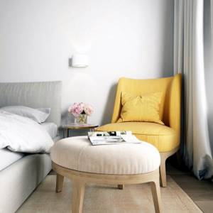 круглый пуфик-оттоманка и мягкое желтое кресло в квартире
